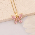 Élégant collier doré avec pendentif papillon rose sur fond neutre minimaliste - Papillon