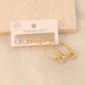 Dettaglio del set di orecchini in acciaio dorato con ciondoli a stella, cuore e fiore - Stile Margherita
