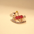 Macro detail van hobbelpaard broche met rood emaille en fonkelende strassteentjes - Rood