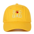 Close-up of yellow cotton baseball cap with white Dog Dad embroidery and red paw print detail - One Size / Yellow