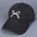 Detailaufnahme der weißen Schleifenstickerei auf der schwarzen Denim-Baseballkappe - M / Schwarz