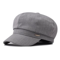 Détail d'un béret gris de style Baker Boy avec une plaque en métal doré rose sur le côté - Taille unique / Kaki