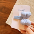 Close-up of a light blue quilted fabric bow hair clip on a display card for girls - Hair Clip / Blue