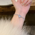 Close-up of heart-shaped zircon bracelet with sparkling diamonds on a wrist - S487 Silver