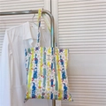 Detailed view of floral canvas tote bag with woven label on a wooden door background - Blue Green Striped Floral