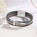 Detailed close-up of multilayer leather bracelet with cross charm and magnetic clasp - Gray