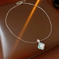 Detalle de colgante de trébol con piedras de corazón azules, perlas y diamantes sobre cuero - Plateado/Azul
