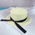 Close-up of beige flat-top straw hat with black bow ribbon and fine woven texture - M (56-58cm) / Milk White