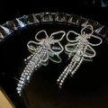 Macro shot of silver crystal bow earrings with long sparkling rhinestone tassels - Silver (Silver Pin)