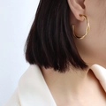 Gekreuzte Twist-Ohrringe mit doppelter Schicht und 18k Goldfinish am Modell getragen - Gold