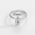 Detail eines silbernen verstellbaren Rings mit T-Form und Tropfen-Metallelementen - Buchstabe T