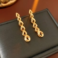 Macro shot of gold wheat-ear fringe earrings on black leather display case - Silver Pin - Gold (18K Gold Plated)