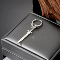 Silver punk dagger hoop earring displayed on a jewelry box with wood background - Dagger