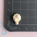 Makro-Detail eines 1,5 cm cremefarbenen Harz-Blumenanhängers mit rosa Akzenten - Gelbes Käse-Eis am Stiel