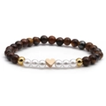 Bracciale di perle occhio di tigre con ciondolo a cuore oro rosa su sfondo bianco - Cuore