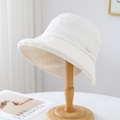 Chic cream white sun hat with pleated texture and subtle gold metal tag on wooden stand - 80846 White