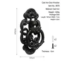 Antique black cast iron oval door knocker with ornate vintage design and mounting screws - Black