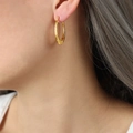 Pendientes en forma de U bañados en oro con textura martillada vista lateral en modelo - Dorado