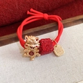 Détail d'un élastique à cheveux rouge avec breloque cheval doré et pendentif strass - Rouge - Cheval - Joie