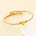Dettaglio di un ciondolo a cuore dorato su un bracciale a cavo ritorto lucido - Oro (KB191186-XY)