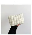 Detailed side view of white quilted padded makeup bag with gold metal zipper closure - White
