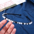 Close-up of 6mm natural crystal stone beads with marble texture on black headband - 6mm Black Rutilated Quartz