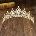 Detailed close-up of a golden baroque crown with colorful rhinestones on a wooden table - Gold + AB Rhinestones