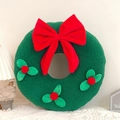 Detail of green sherpa Christmas wreath pillow with red bow and berry leaf accents - Wreath Shape