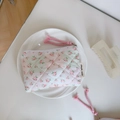 Close-up of quilted floral coin purse with a side label on a white ceramic plate - Light Green Pink Grid Small Flower