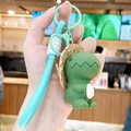 Green resin dinosaur keychain with a straw hat and light blue braided hand strap - Resin Straw Hat Dinosaur-Dark Green