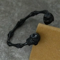 Vista detallada de la pulsera de esqueleto negro estilo punk con diseño de puño abierto - Negro