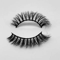 Detail view of fluffy thick black false eyelashes with natural curl on a gray background - D62