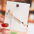 Sparkling gold fishtail hair clip with inlaid rhinestones on a white card display - Gold Fishtail