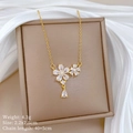 Close-up of gold flower necklace with rhinestones on a brown jewelry box with silk - Gold Flower Water Drop Pendant (A316)