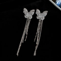 Primer plano de pendientes de mariposa en plata con pedrería y cadenas largas con borlas - Clip de oreja - Plata