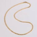 Dettaglio ravvicinato di una collana a catena barbazzale piatta dorata su sfondo bianco - Oro