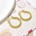 Makro-Detail vergoldeter gedrehter Creolen auf Vintage-Umschlag und Keramikplatte - Drahtdurchmesser 3mm / Gold