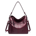 Close-up of wine red leather tote bag showing metallic zippers and tassel detail - Single Bag / Burgundy