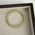 Champagne gold clover spiral phone cord hair tie on a minimalist woven tray - Beige Slim