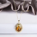 Makroaufnahme des goldenen religiösen Anhängers mit Herzrahmen und Zirkonia-Einlage - Hl. Josef und Jesuskind (2)