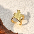 Golden starfish ring with textured surface on a rustic beige background - Gold