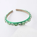 Detailed view of green fabric headband with emerald crystals and rhinestone borders - Green