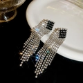 Dettaglio di orecchini a nappa in argento con diamanti su piatto bianco e fondo nero - Stile Nappa Rombo Nero Argento / Argento (Perno per orecchini in argento sterling 925)