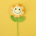 Close-up of handmade crochet sunflower with smiley face and green leaves on yellow backdrop - Gradient Yellow - Smiley Face Sunflower Branches