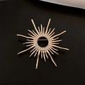 Broche soleil plaquée or 18k avec zircons sertis sur un fond noir à texture élégante - Or (Plaqué Or 18K)