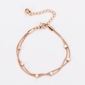 Detalle de pulsera de doble cadena de oro rosa con dijes cuadrados y cierre de langosta - Oro rosa