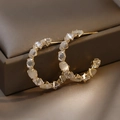 Detail of C-shaped gold hoop earrings with opal and zircon accents on a jewelry box - Large C-Shaped Hoop