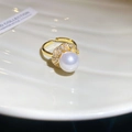 Macro detail of a gold flower ring featuring a large pearl surrounded by zircons - 51# Ring - Gold - Flower