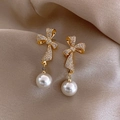 Close-up of gold bow earrings with pavé zircon settings and hanging white pearls - Gold Bowknot Rhinestone Pearl Earrings (26# Silver Needle - Gold (Eco))