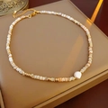 Detalle de cuentas de concha y perla barroca en un collar bañado en oro de 14K - Collar con Colgante de Perla y Concha / Dorado-Caqui